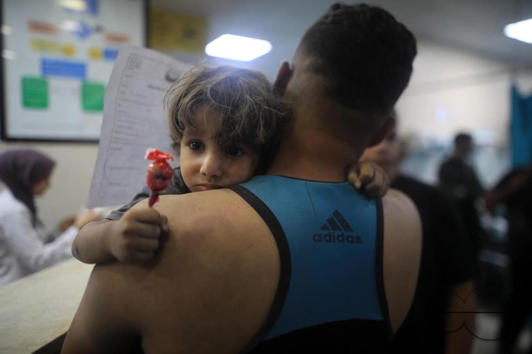 A Palestinian father hugs his daughter at a hospital after his house was targeted by Israeli air strikes in Gaza
