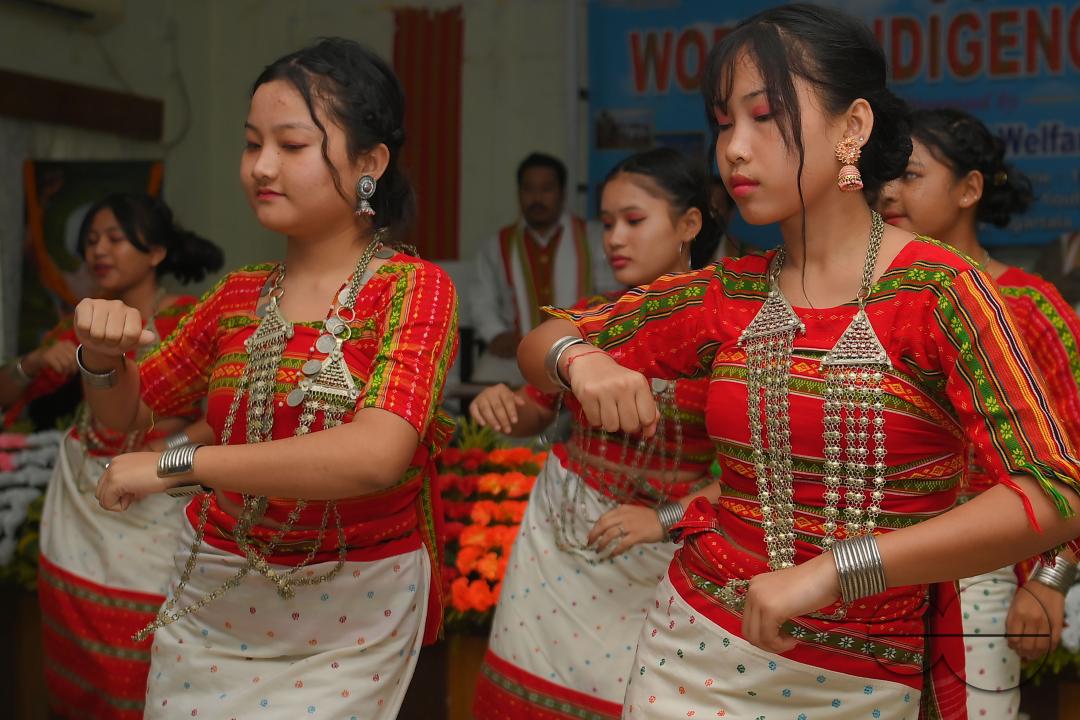 Indigenous girls perform traditional dances on the occasion of World Indigenous Day in an auditorium at Agartala