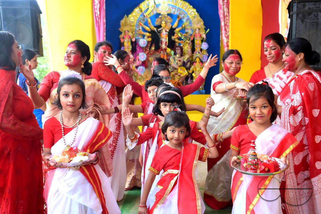 Children and married women are dancing, and the women smear each other with vermillion during a ritual called the vermillion game, or "Sindur Khela," on the last day of the Durga Puja festival in Agartala, Tripura, India.