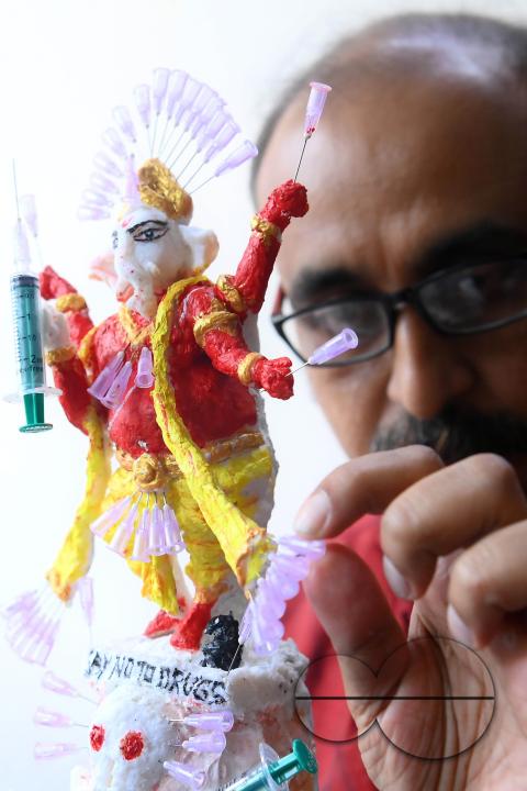 Samiran De, an artist works on an idol of Lord Ganesha made with soup and syringe needles to alert people against drugs, ahead of Ganesh Chaturthi festival, in Agartala