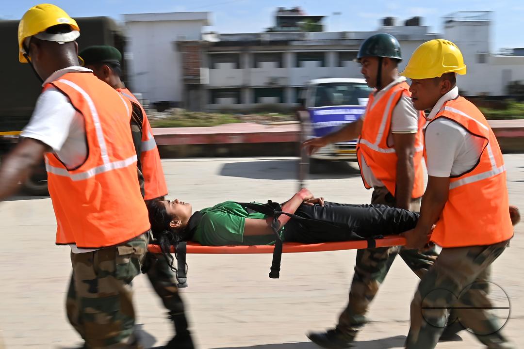 Fire brigade personnel are trying to control a fire on the top of the building of the dental college during a state level mock exercise on earthquake day at Agartala