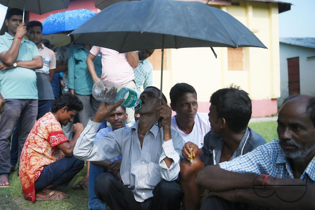 Voters wait in a queue to cast their votes during the by-elections for the Boxonagar assembly seat, in Tripura Sepahijala district