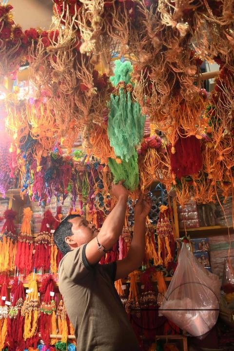 A shop owner arranging "Rakhi", sacred threads for the upcoming "Raksha Bandhan" festival at his shop in Agartala