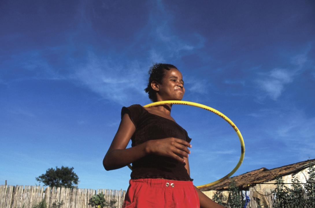 BRAZIL GIRL PLAYING 'HOOLA-HOOP' IN A 'SEM TERRA' , LANDLESS PEASANT SETTLEMENT BAHIA STATE  Photo  Julio Etchart