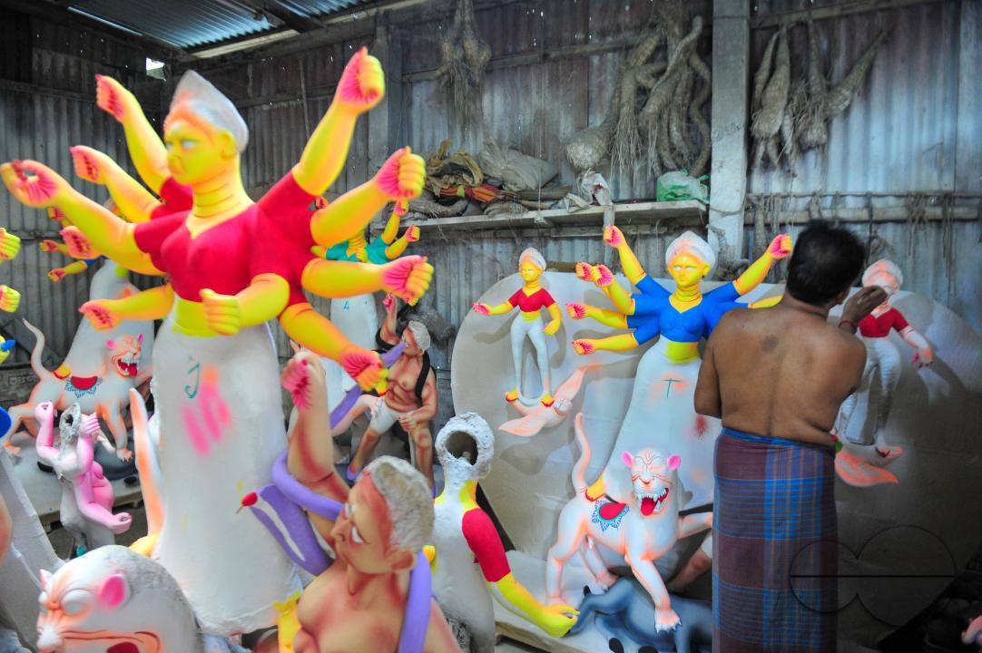 Dulal Paul, a veteran Idol Artist is colouring structures of a Hindu Deity in preparation for the upcoming Durga Puja Festival