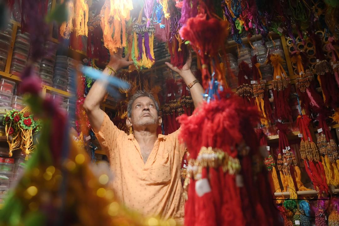 A shop owner arranging "Rakhi", sacred threads for the upcoming "Raksha Bandhan" festival at his shop in Agartala
