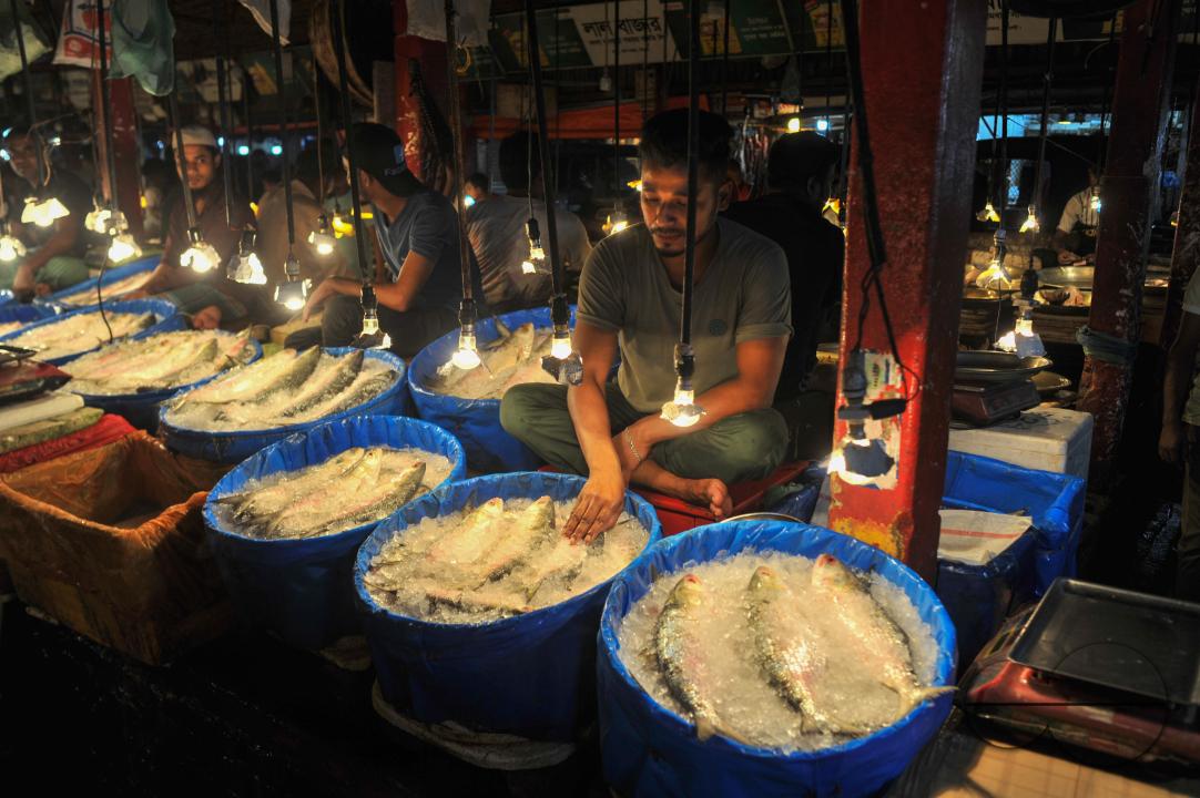 People buy Hilsa fish at the Lalbazar fish market in Sylhet city
