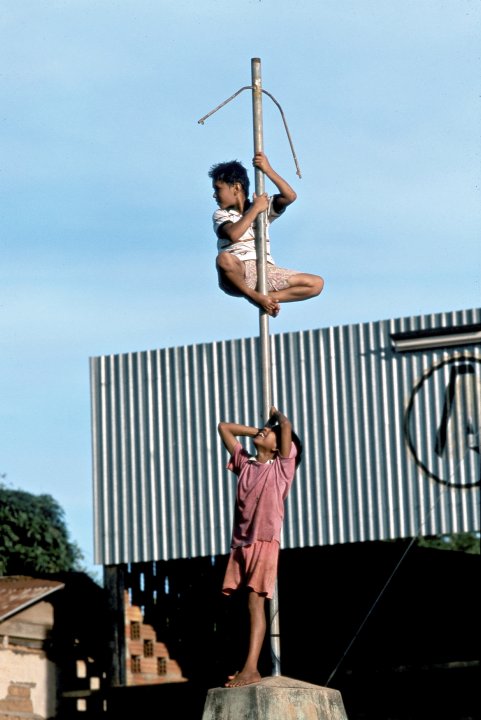 PERU CLIMBING A POLE IN A VILLAGE IN THE AMAZON REGION PHoto Julio Etchart