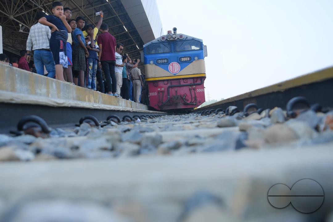 Indian people looking at a trial train and taking photographs, which is crossing the Indo-Bangladesh border