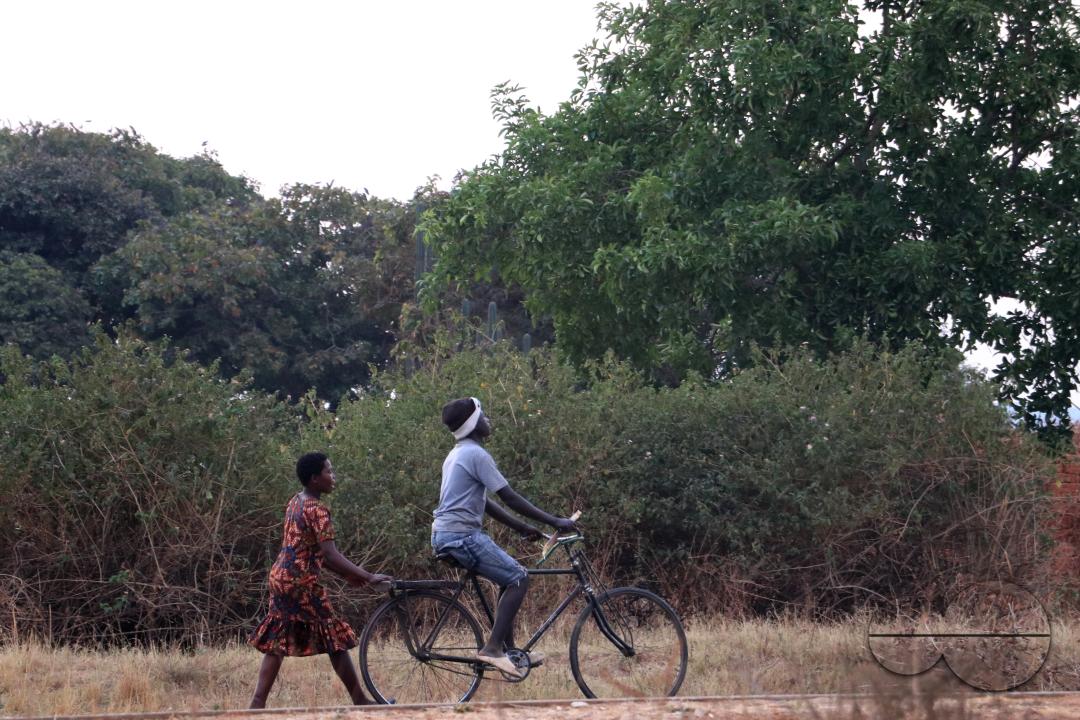 Young woman riding a bicycle in Mchinji District Malawi