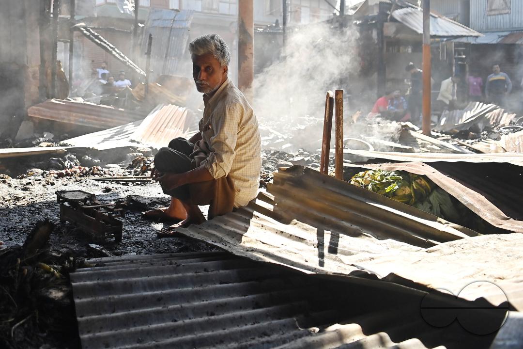 Shop owners and vendors are seen in front of their burnt shops and vegetables stalls in Battala market, the second biggest market in Tripura