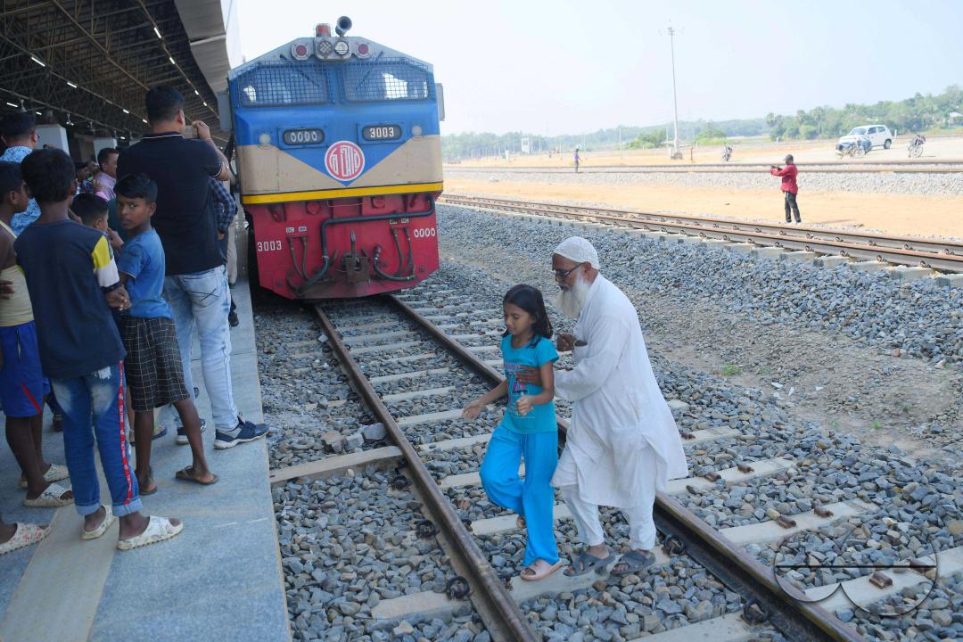 Indian people looking at a trial train and taking photographs, which is crossing the Indo-Bangladesh border