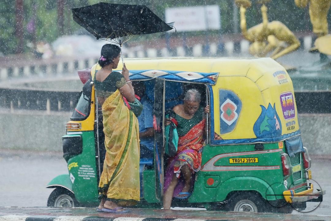 Train passengers are coming to Agartala railway station to catch the rescheduled interstate trains in heavy rain during Cyclone Remal in Agartala