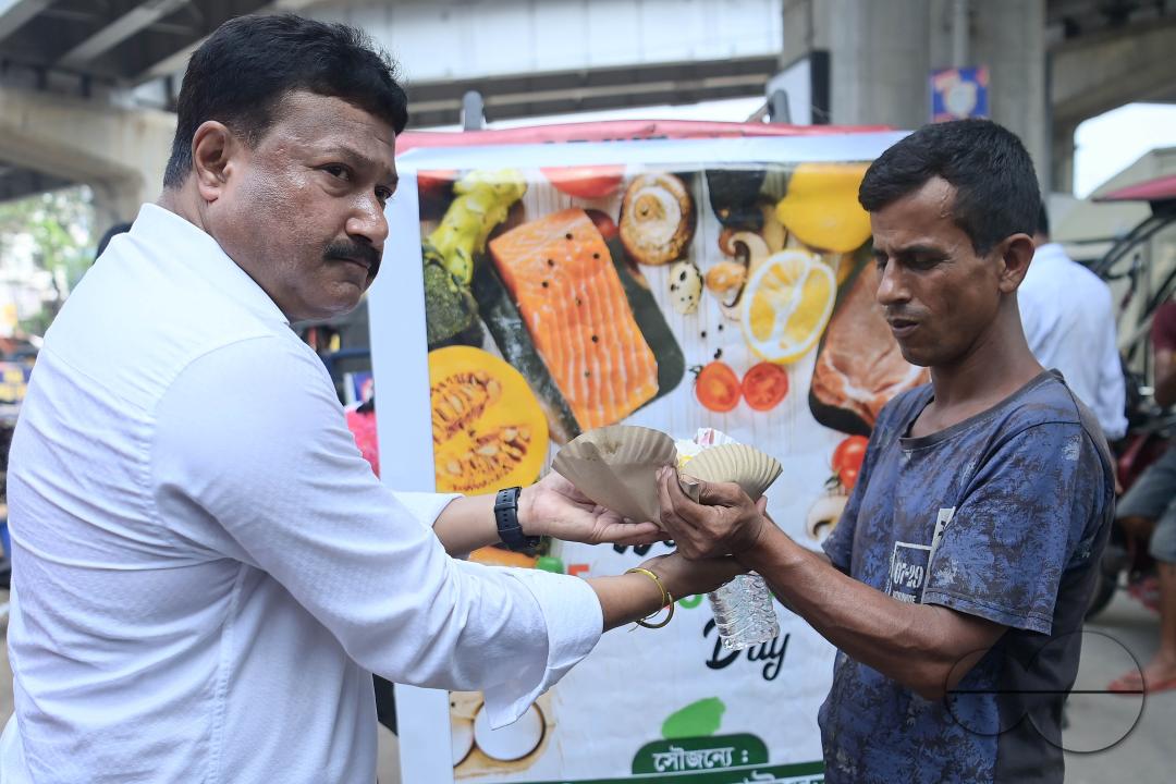 People get food from a social worker on World Food Safety Day, organised by Rotary Club of Agartala, in Agartala