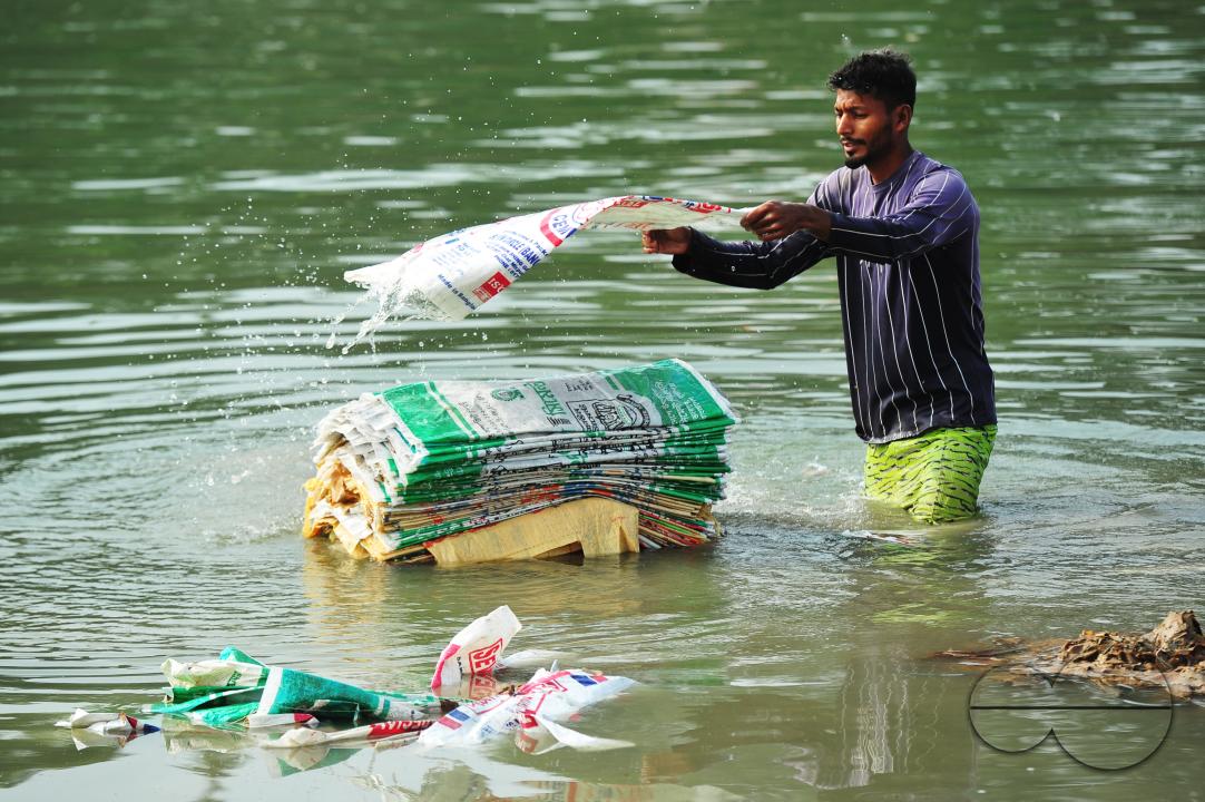 Women are risking their lives to wash cement bags beside the Surma River in Sylhet