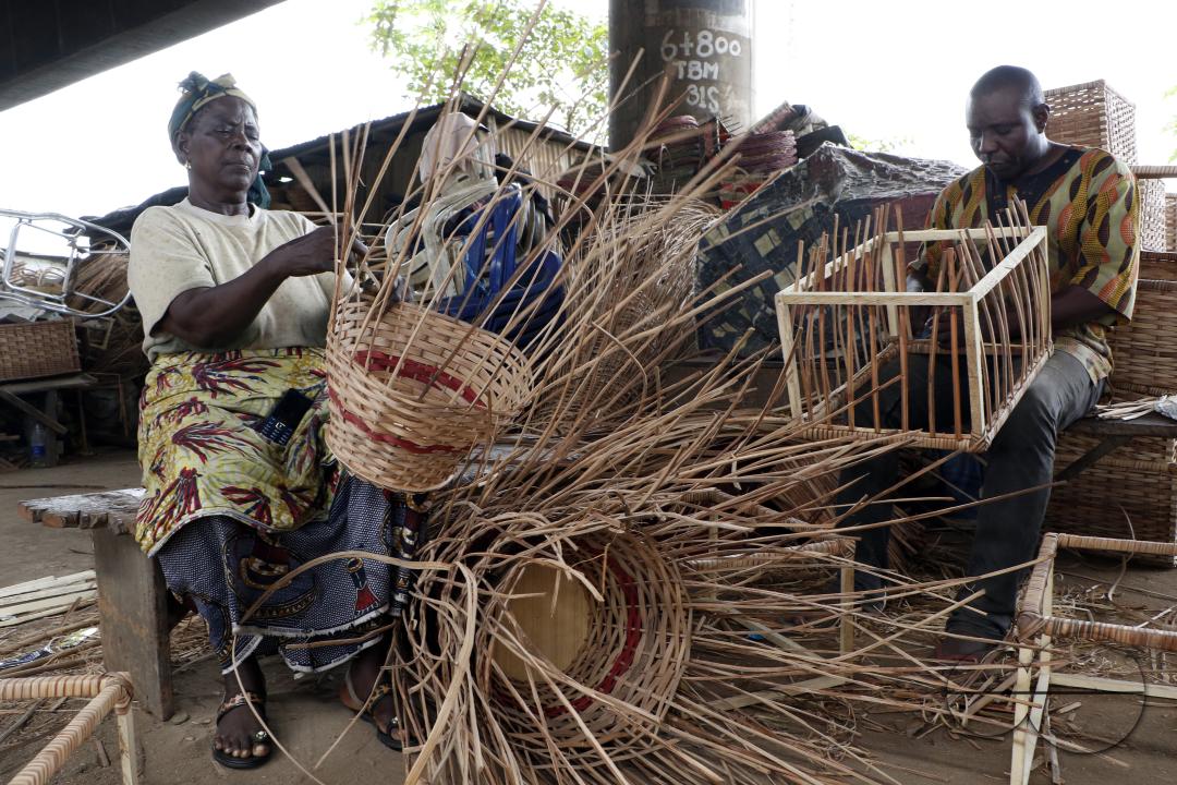 People weave a household basket at Nigeria's largest cane 'village' at Mende in the Maryland District of Lagos