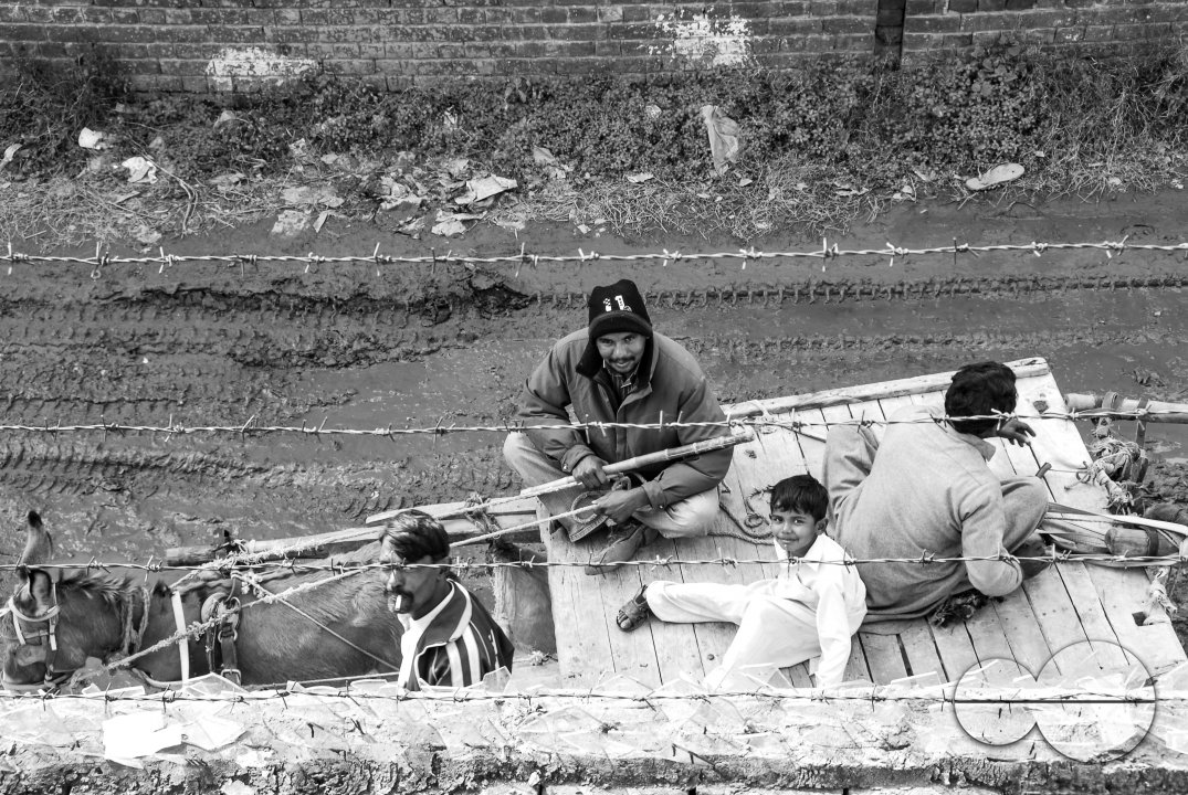 People sit on a cart pulled by a donkey, Lahore.