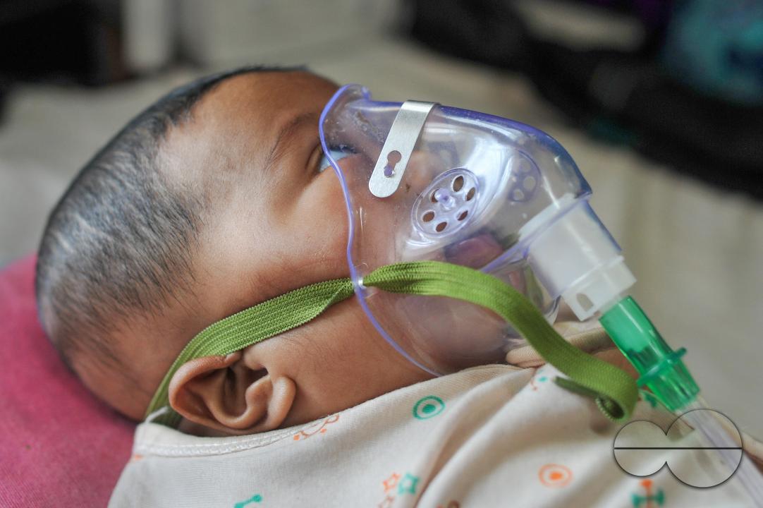A senior nurse is providing medical care to a child in Sylhet MAG Osmani Medical College Hospital