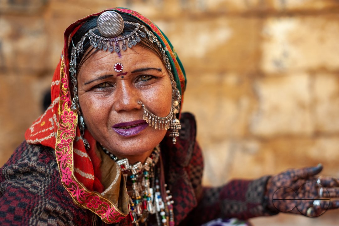 A street vendor in Jaisalmer asking passers-by to purchase the jewellery she is selling.