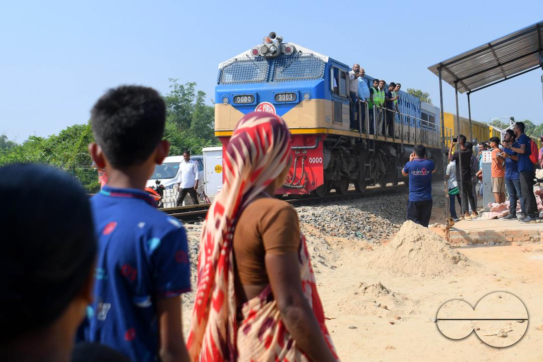 Indian people looking at a trial train and taking photographs, which is crossing the Indo-Bangladesh border