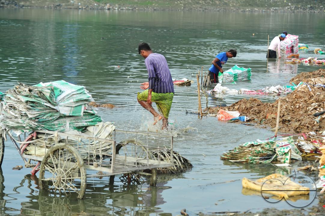 Women are risking their lives to wash cement bags beside the Surma River in Sylhet
