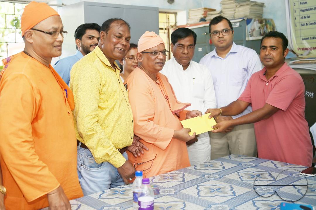 Santosh Gope, Secretary of the Agartala Sports Journalist Association, donates money to Swami Shubhakarananda (Maharaj) - Secretary of Ramakrishna Mission, in the presence of Mayor Deepak Majumdar, the District Magistrate, and other officials inspect a h