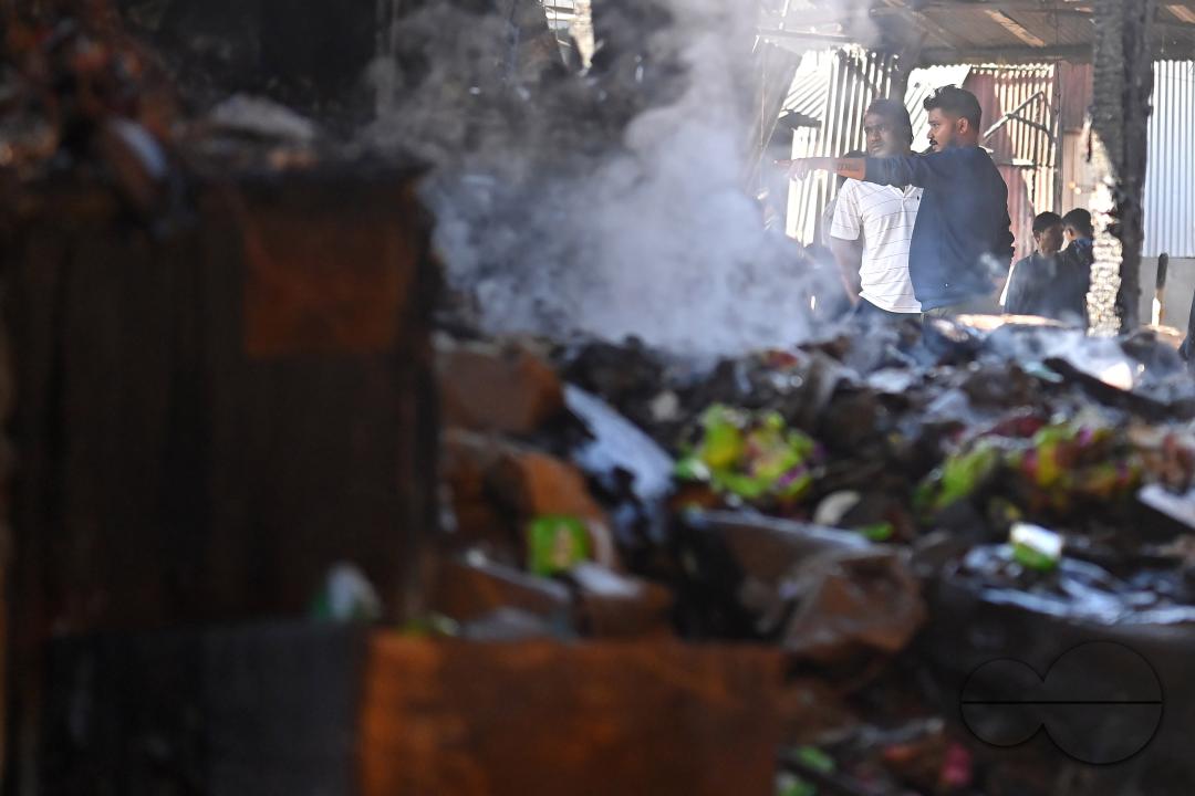 Shop owners and vendors are seen in front of their burnt shops and vegetables stalls in Battala market, the second biggest market in Tripura