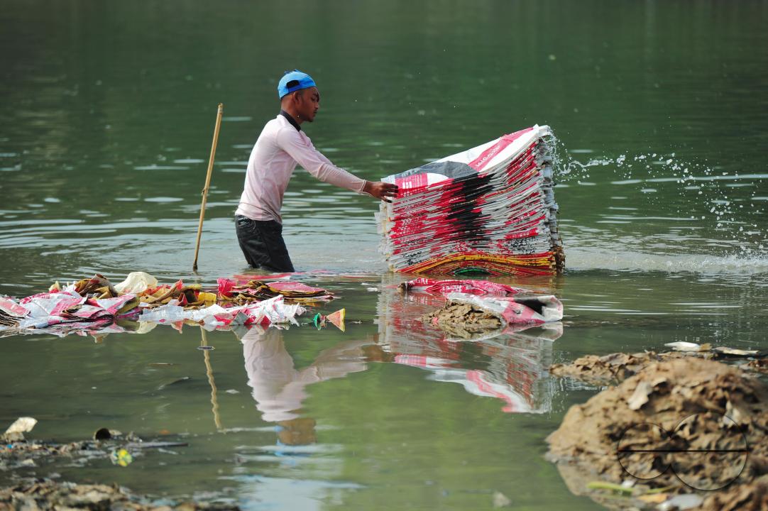 Women are risking their lives to wash cement bags beside the Surma River in Sylhet