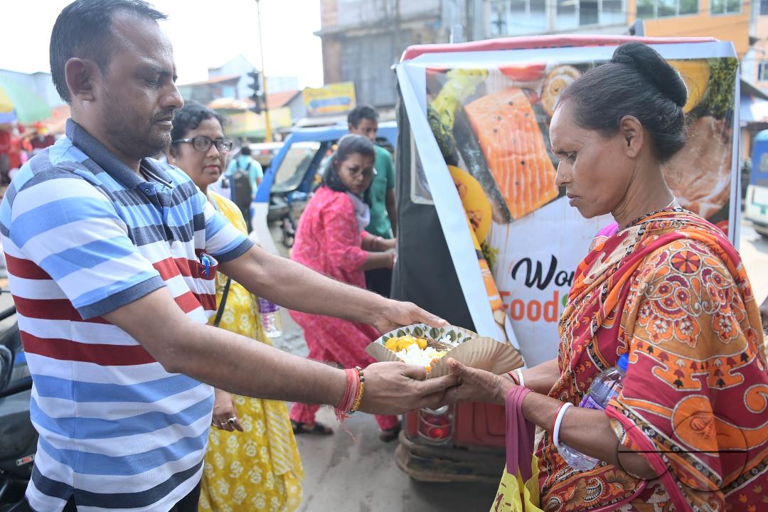 People get food from a social worker on World Food Safety Day, organised by Rotary Club of Agartala, in Agartala