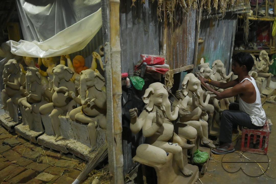 An Idol maker making idols of Lord Ganesh in a studio for the upcoming Ganesh Chaturthi festival at Agartala