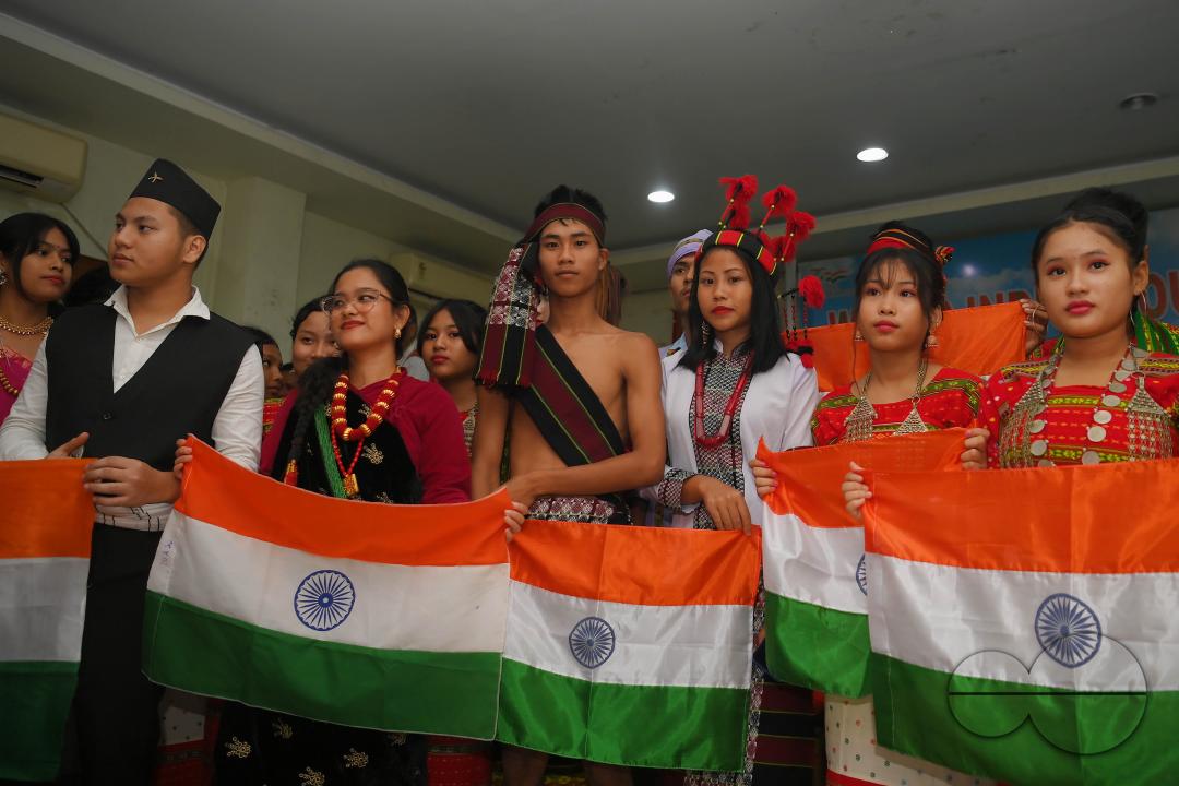 Indigenous girls holding the national flag during a cultural program on the occasion of World Indigenous Day at an auditorium in Agartala
