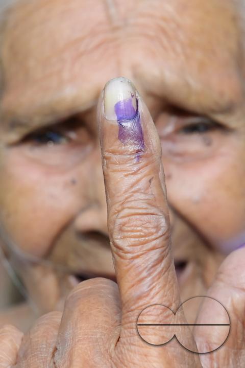 An elderly woman proudly displays her inked finger after voting at the Lok Sabha elections at a Boxanagar polling station in Agartala