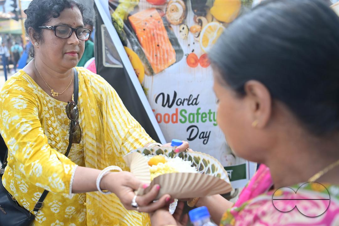 People get food from a social worker on World Food Safety Day, organised by Rotary Club of Agartala, in Agartala