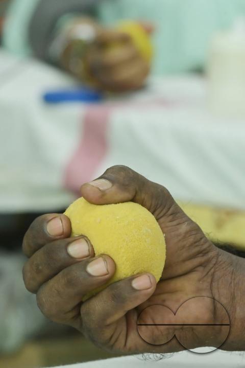 A man squeezes a sponge ball as he donates blood on World Blood Donor Day at a blood donation centre in Agartala