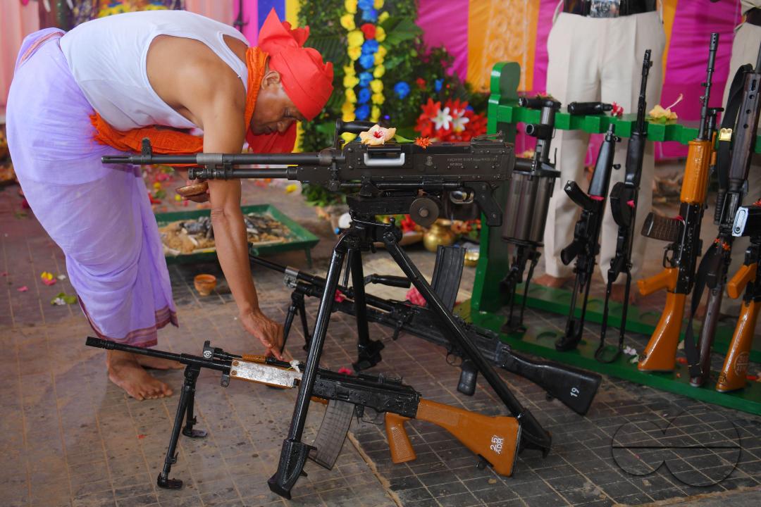 A priest performs worship of arms on Vishwakarma Puja in a TSR (Tripura State Rifles) camp on the outskirts of Agartala