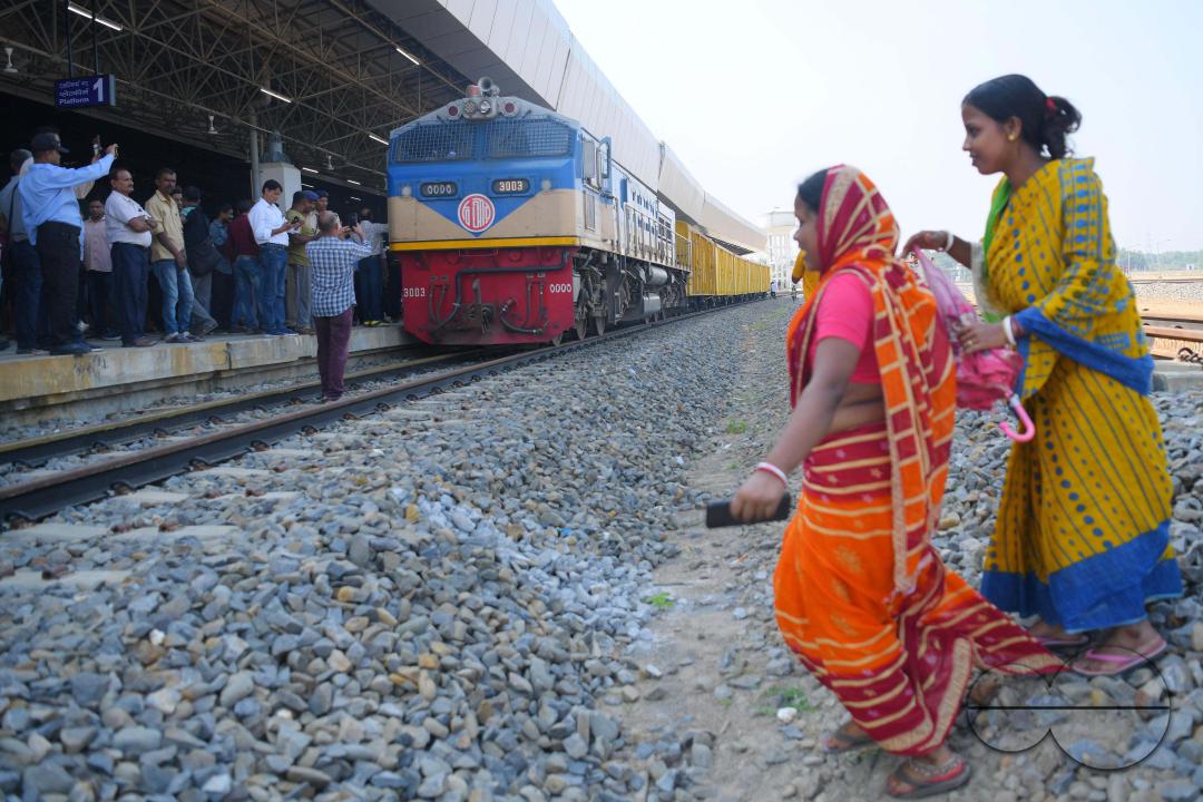 Indian people looking at a trial train and taking photographs, which is crossing the Indo-Bangladesh border