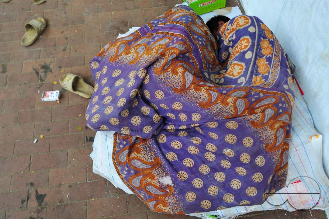 Covering their bodies from head to toe with whatever they can manage, homeless people sleep out in the open in the shivering cold near the Government Alia Madrasa in Sylhet city's Chowhatta area