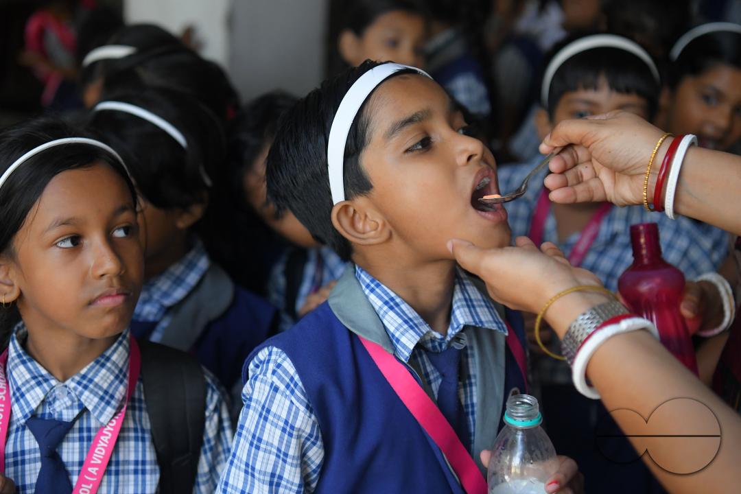 A schoolteacher is giving deworming tablets to the students in a school during the special program of Mukhyamantri Sustho Shoishob, Sustho Kaishore Abhiyan (MSSSKA 5'0) for National Deworming Day
