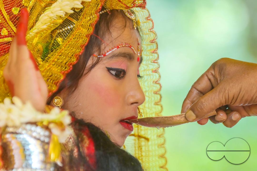 Priests worship a nine-year, five-month, and fourteen-day-old Hindu girl, Debalina Chakraborty, known as a "Kumari," who yawns during the Durga Puja religious festival at the Ramakrishna Vivekananda Ashram, operated by the Ramakrishna Mission on the outs