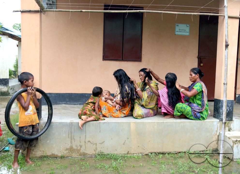 Rural Bangladeshi women use fingers to separate hair and create a part