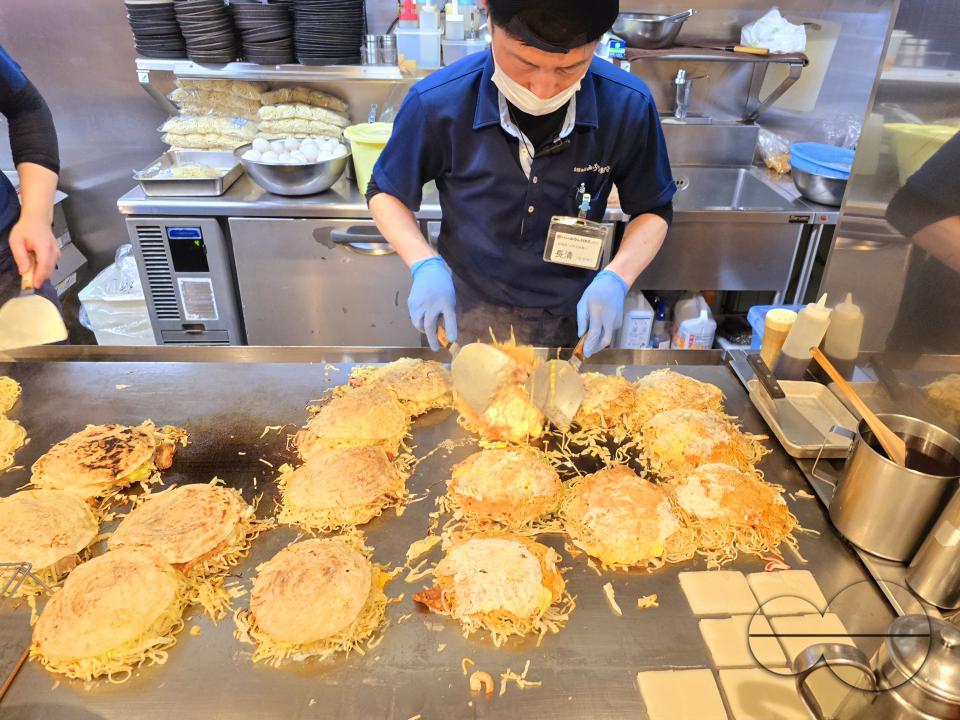 Chefs preparing Okonomiyaki, known as Hiroshimaâs soul food and served in some 2,000 restaurants in and around the city