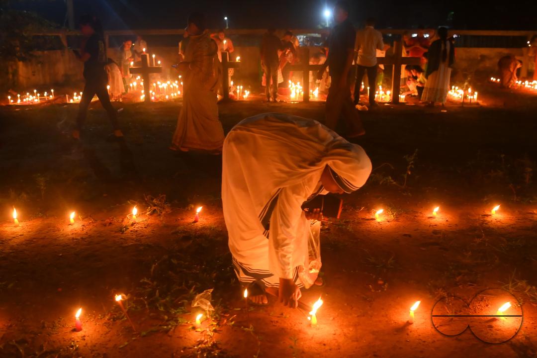 Nuns offer prayers next to the graves of their family members at a cemetery during "All Souls Day" on the outskirts of Agartala