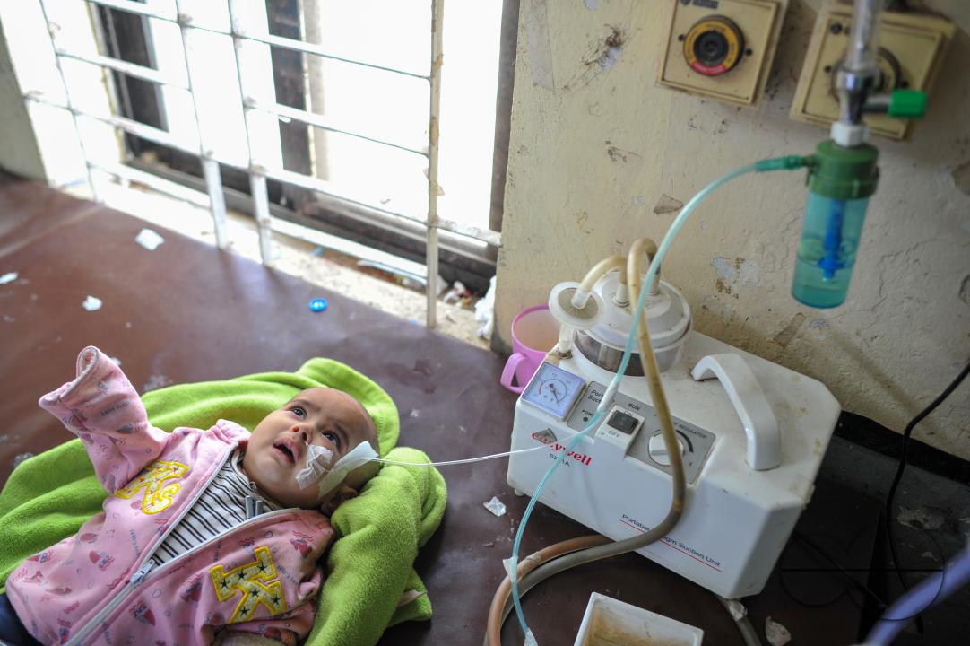 A senior nurse is providing medical care to a child in Sylhet MAG Osmani Medical College Hospital