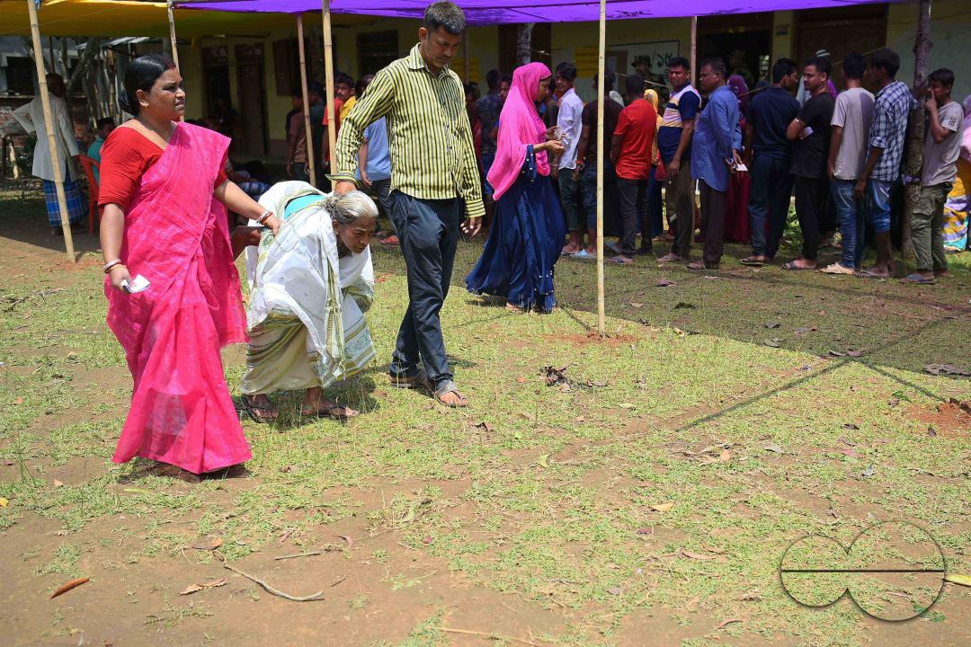 Volunteers assist an elderly lady after she casts her vote in the first phase of Lok Sabha elections at a Sonamura polling station in Agartala