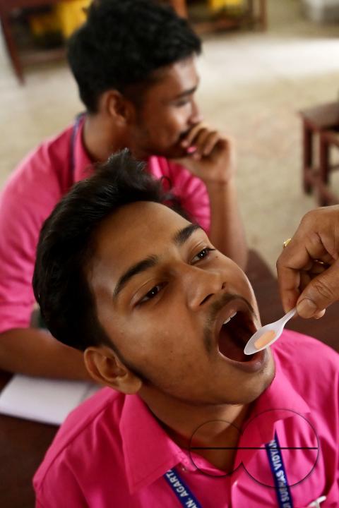 A student of Netaji Subhash Vidyaniketan High School is taking a deworming tablet during the special program "Mukhyamantri Sustho Shoishob, Sustho Kaishore Abhiyan (MSSSKA 7.0)" in Agartala