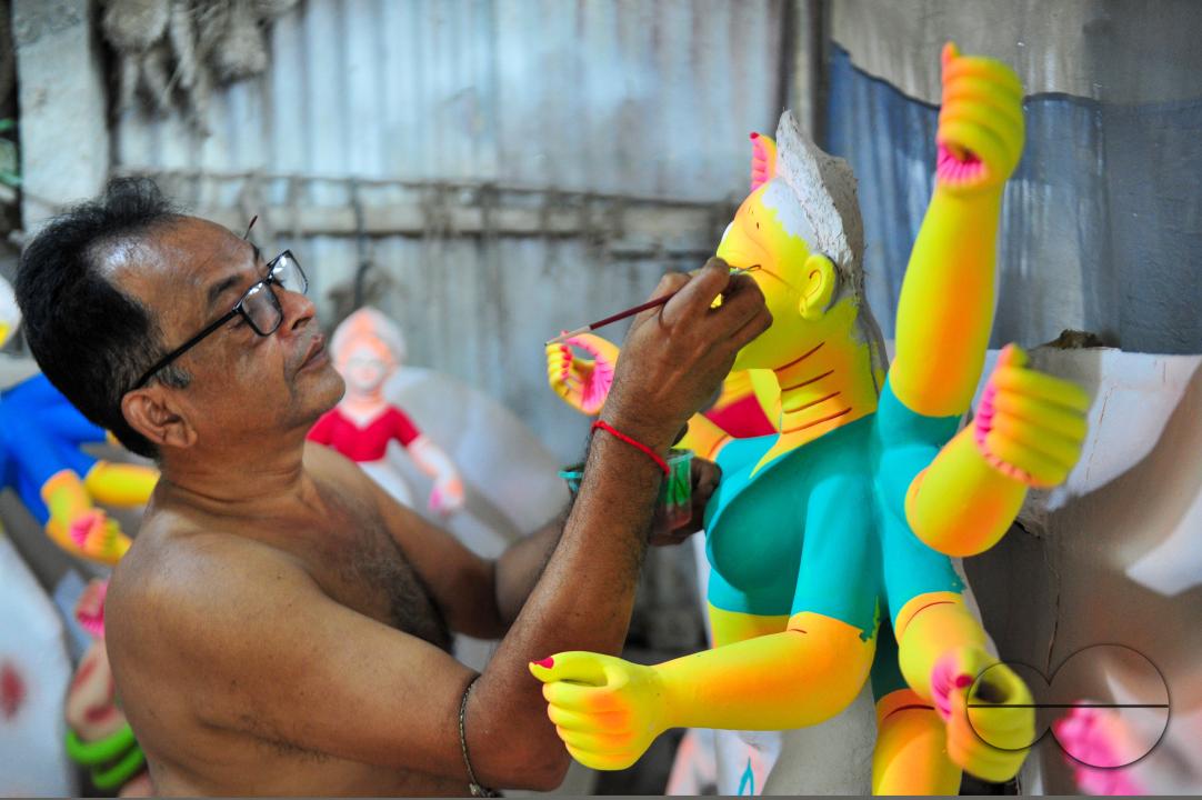 Dulal Paul, a veteran Idol Artist is colouring structures of a Hindu Deity in preparation for the upcoming Durga Puja Festival