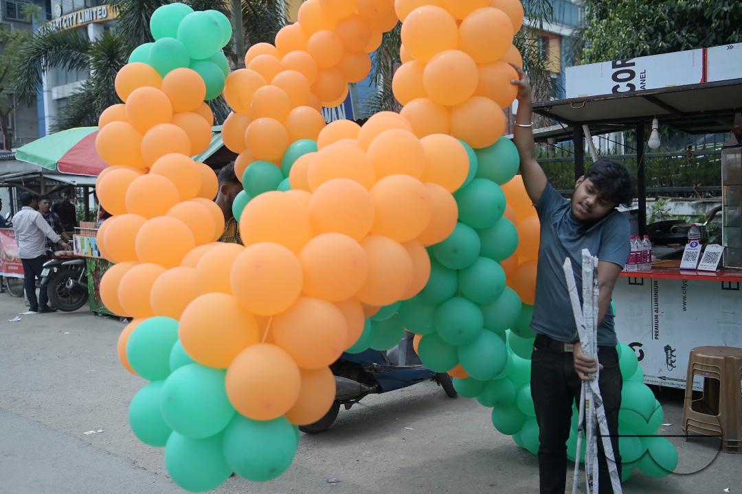 Supporters of the BJP are seen decorating balloons in the party's colours at a rally featuring Tripura Chief Minister Manik Saha, former CM and BJP candidate Biplab Kumar Deb, and Kriti Singh, alongside other leaders, during an election campaign rally in