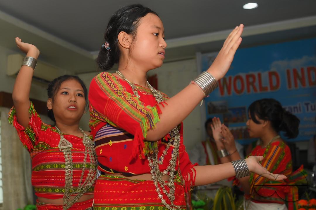 Indigenous girls perform traditional dances on the occasion of World Indigenous Day in an auditorium at Agartala