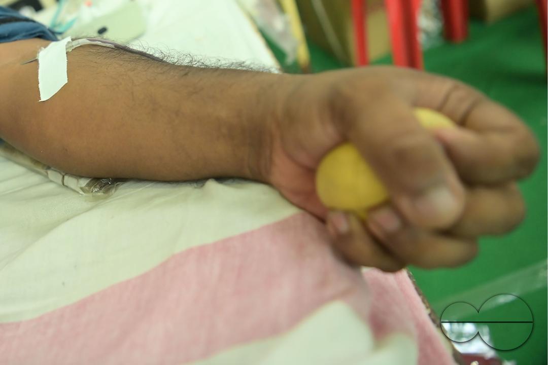 A man squeezes a sponge ball as he donates blood on World Blood Donor Day at a blood donation centre in Agartala