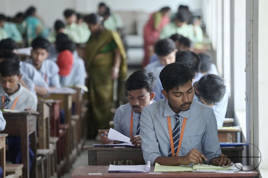 Students are seen writing an English paper